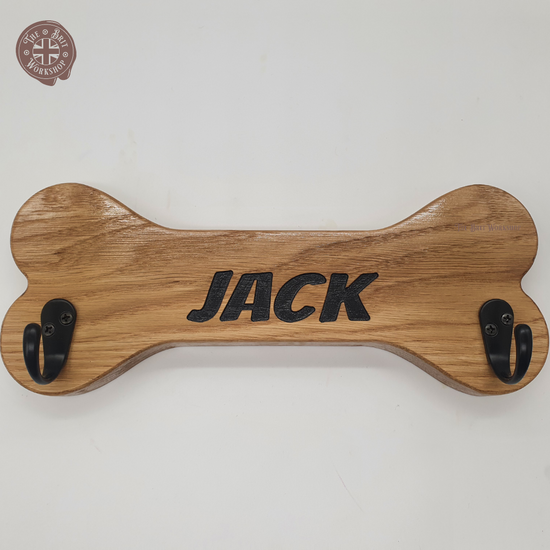 Bone shaped oak dog lead hanger with two black hooks and 'Jack' engraved in the middle